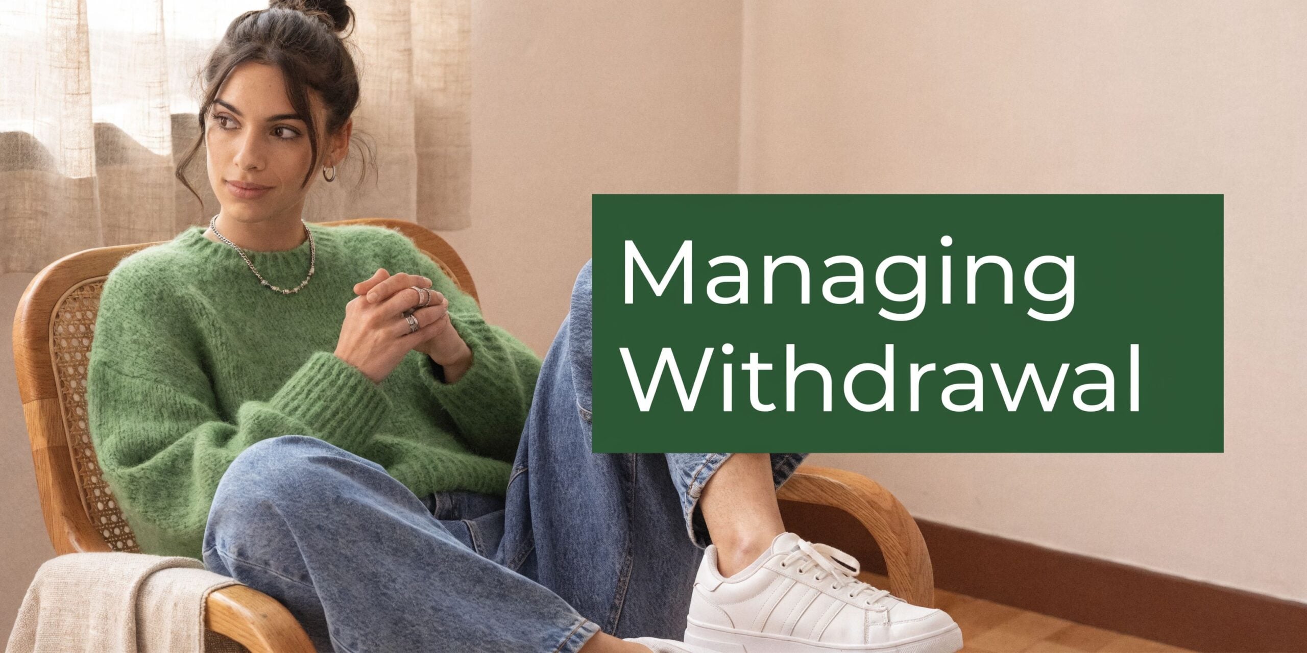 A woman in a green sweater sitting in a wooden chair with text overlay saying Managing Withdrawal.