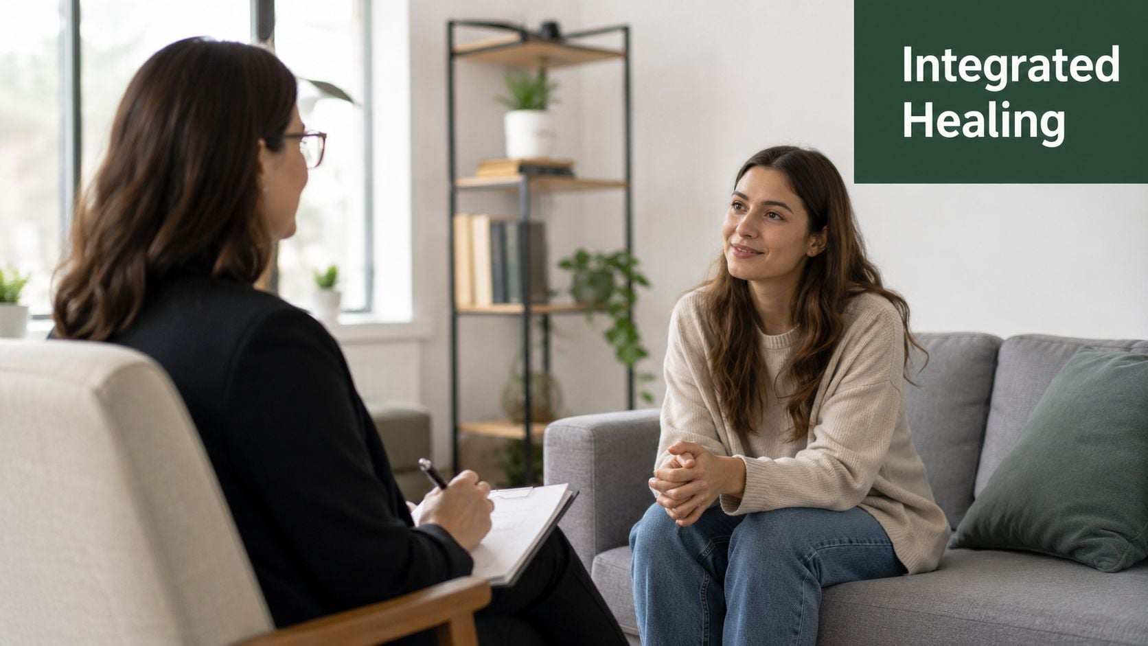 A professional therapist taking notes during a consultation session with a smiling woman on a sofa.